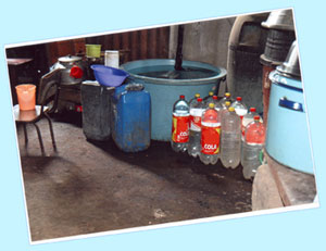 Photo showing jugs of water collected and stored before teh water project