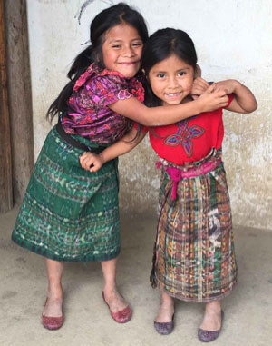 Two smiling Guatemalan girls pose together