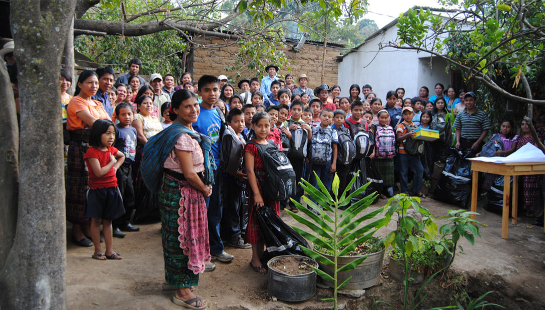 A photo of Mayan people showing children with donated backpacks